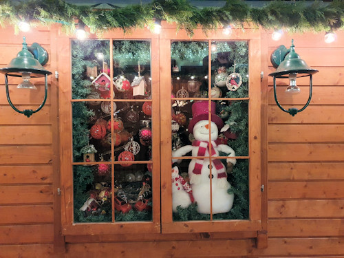 Christmas decorations in the window of a wooden market hut