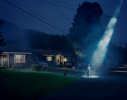 Man in a spotlight outside house