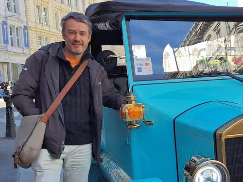 Man standing next to an old timer